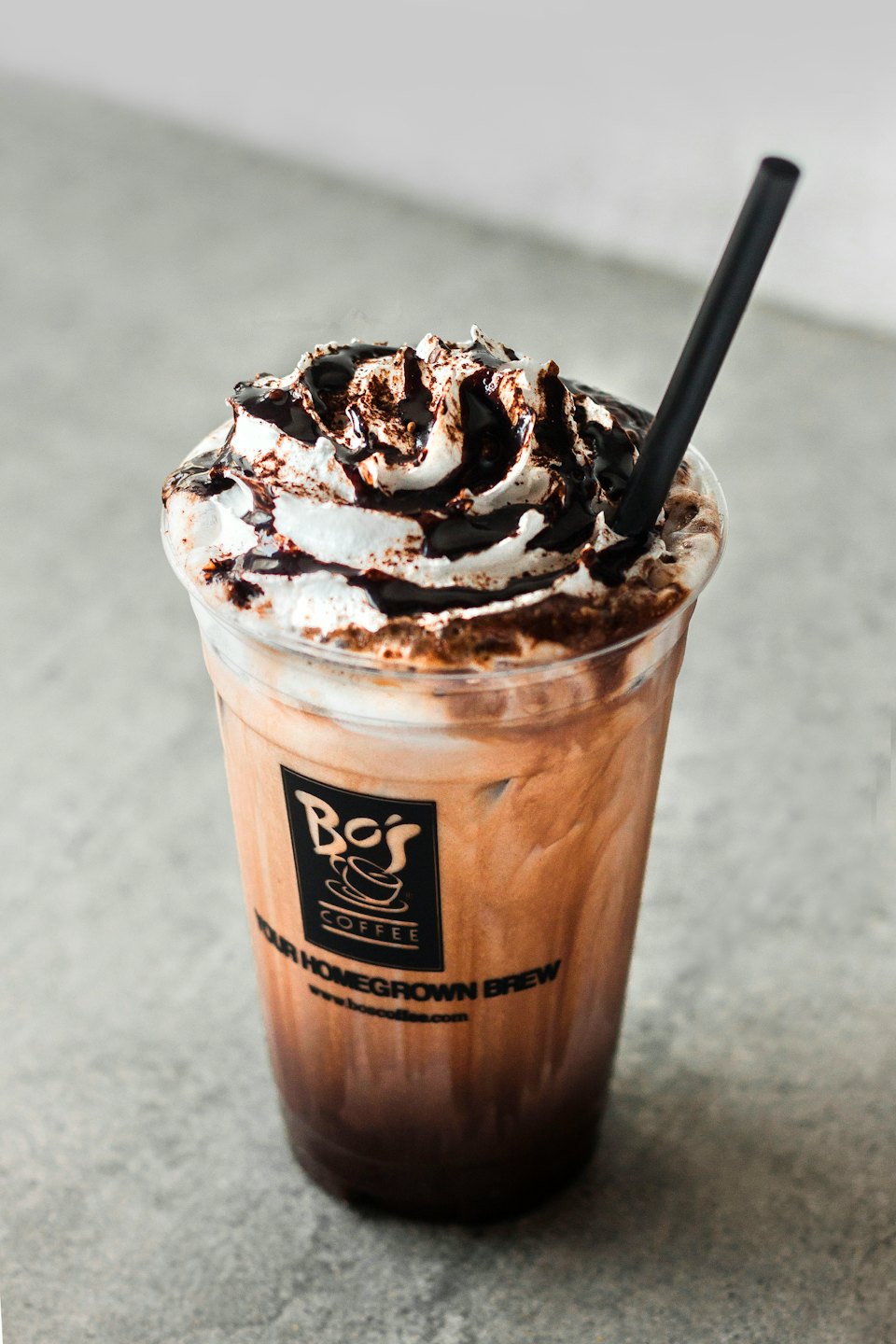 Iced chocolate coffee topped with whipped cream and chocolate syrup.