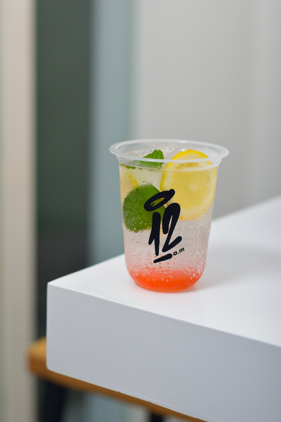Refreshing drink with fruit slices and mint in a cup.