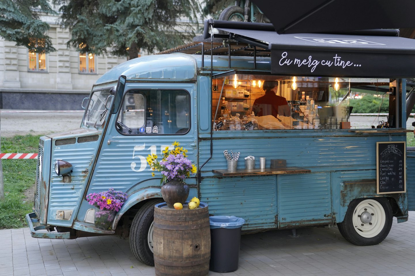 A vintage blue food truck serves coffee from a mobile shop.